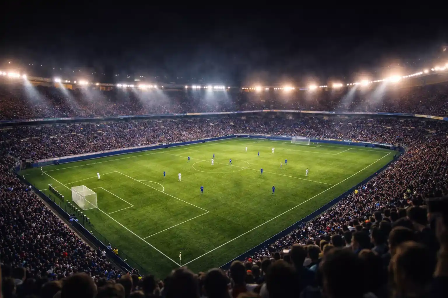 Vue panoramique d'un stade de Ligue 1 rempli de supporters lors d'un match de football en soirée